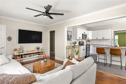 a living room with furniture kitchen view and a flat screen tv