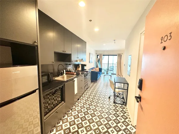a kitchen with a sink a refrigerator and cabinets