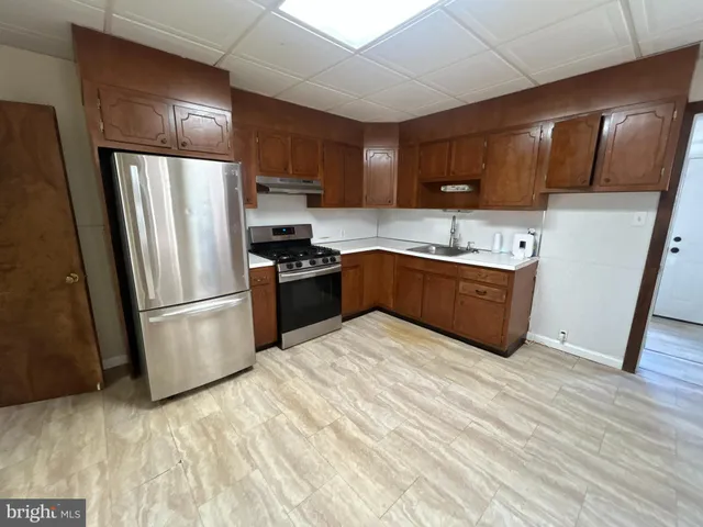 a kitchen with stainless steel appliances granite countertop a refrigerator a sink dishwasher a stove top oven a refrigerator and dishwasher