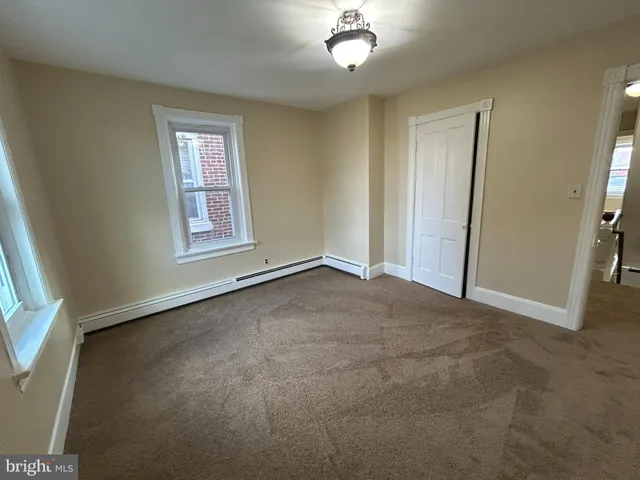 an empty room with windows and closet