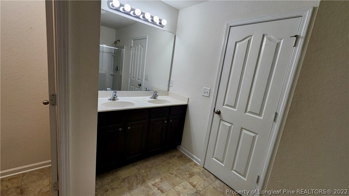 286 Botanical Court Bunnlevel, NC 28323 - Photo 31 of 39 a bathroom with a double vanity sink and mirror