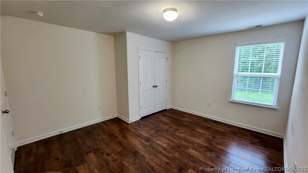 286 Botanical Court Bunnlevel, NC 28323 - Photo 32 of 39 an empty room with wooden floor and windows