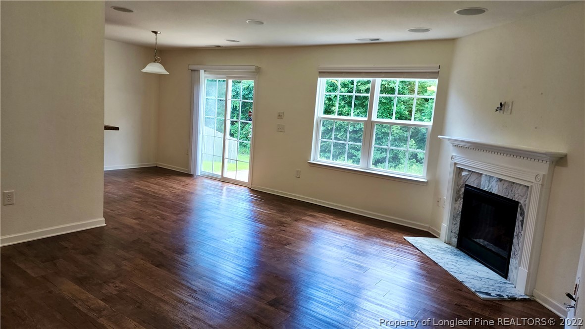 286 Botanical Court Bunnlevel, NC 28323 - Photo 9 of 39 an empty room with wooden floor fireplace and windows