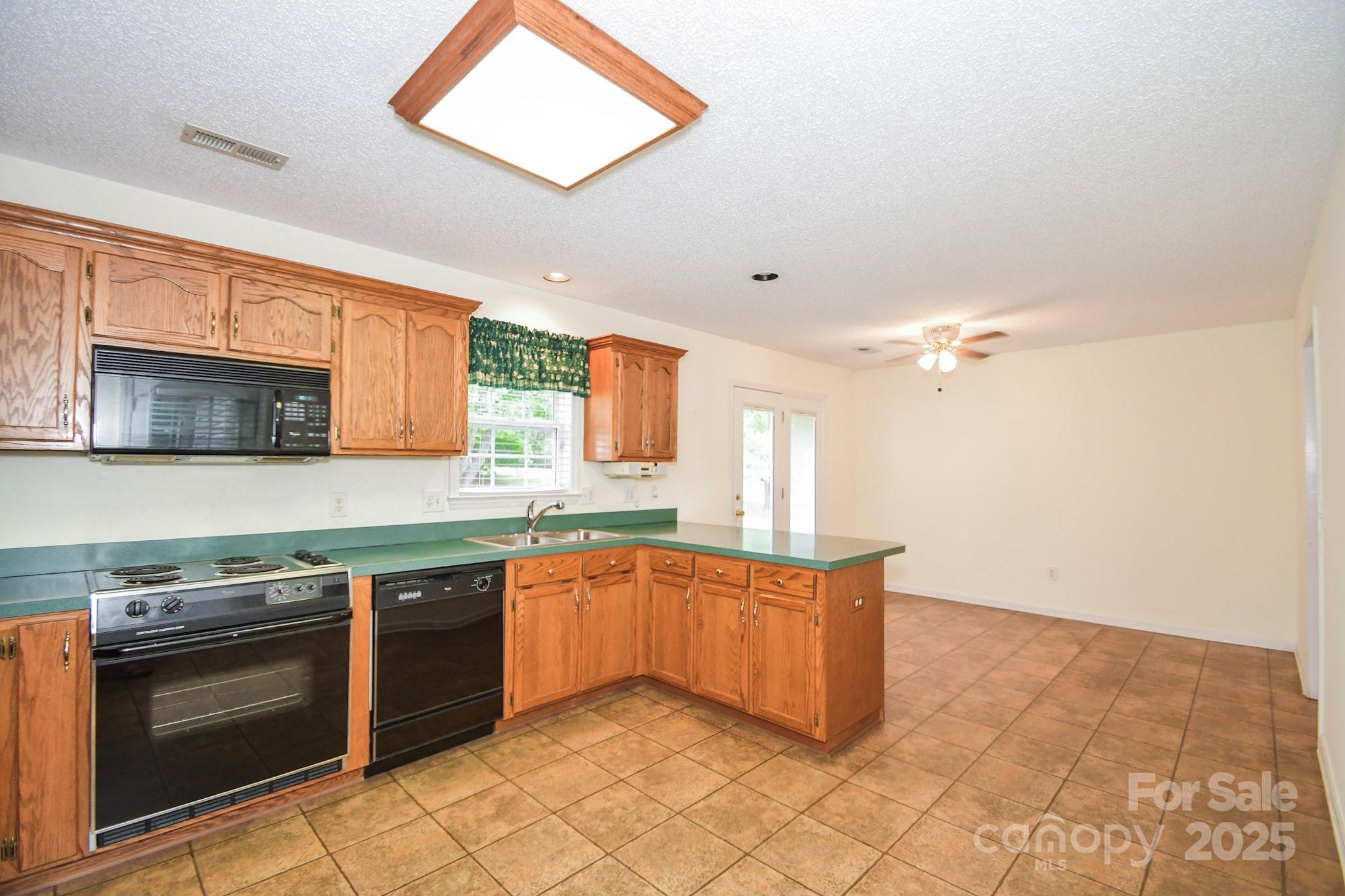 2718 Goldmine Road Monroe, NC 28110 - Photo 16 of 25 a kitchen with stainless steel appliances granite countertop a stove a sink and a microwave