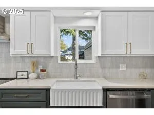 a kitchen with white cabinets a sink and a window
