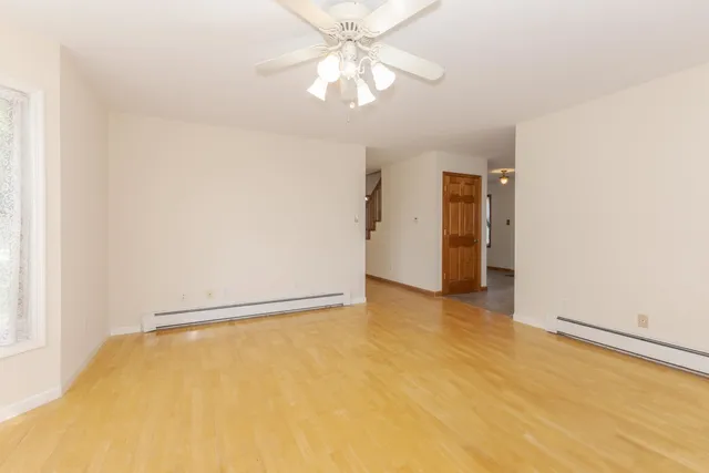 an empty room with a window and a fan