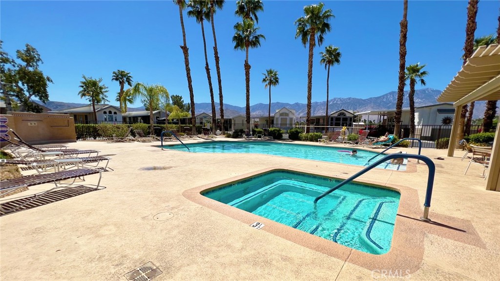 69801 Ramon Road, Unit 57 Cathedral City, CA 92234 - Photo 25 of 47 a view of a swimming pool with a lounge chairs