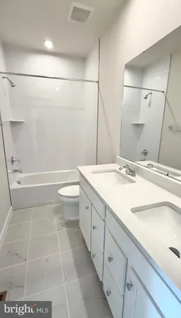 a bathroom with a granite countertop sink a toilet and shower