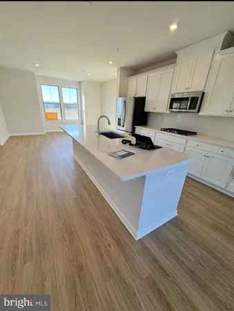 a kitchen with wooden floors and wooden cabinets