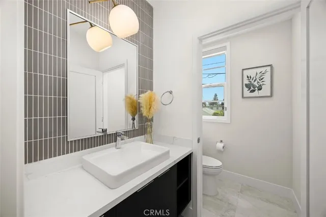 a bathroom with a sink a toilet and a mirror