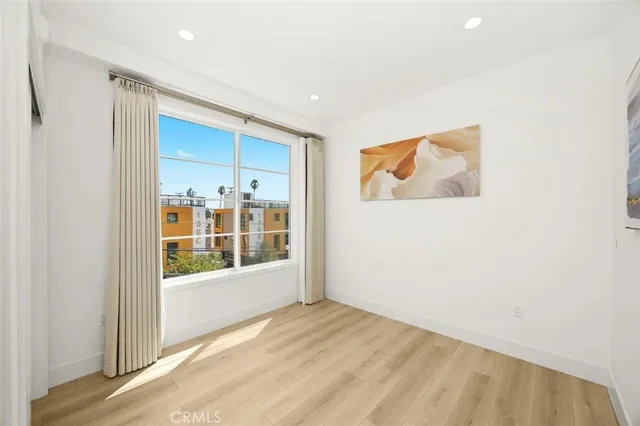 a view of a big room with wooden floor and windows