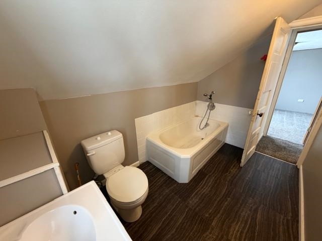 824 12th Street North Virginia, MN 55792 - Photo 24 of 34 Bathroom featuring a bath, vaulted ceiling, and dark wood-type flooring