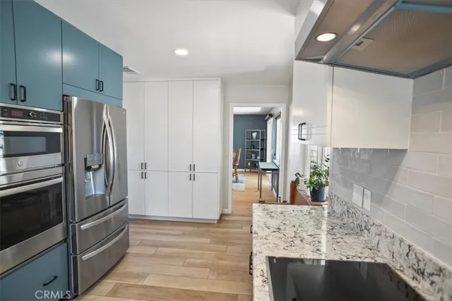 a kitchen with stainless steel appliances granite countertop a refrigerator and a sink