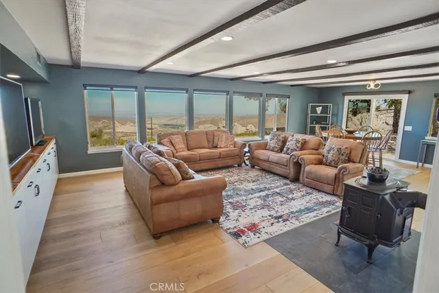 a living room with furniture large windows and wooden floor