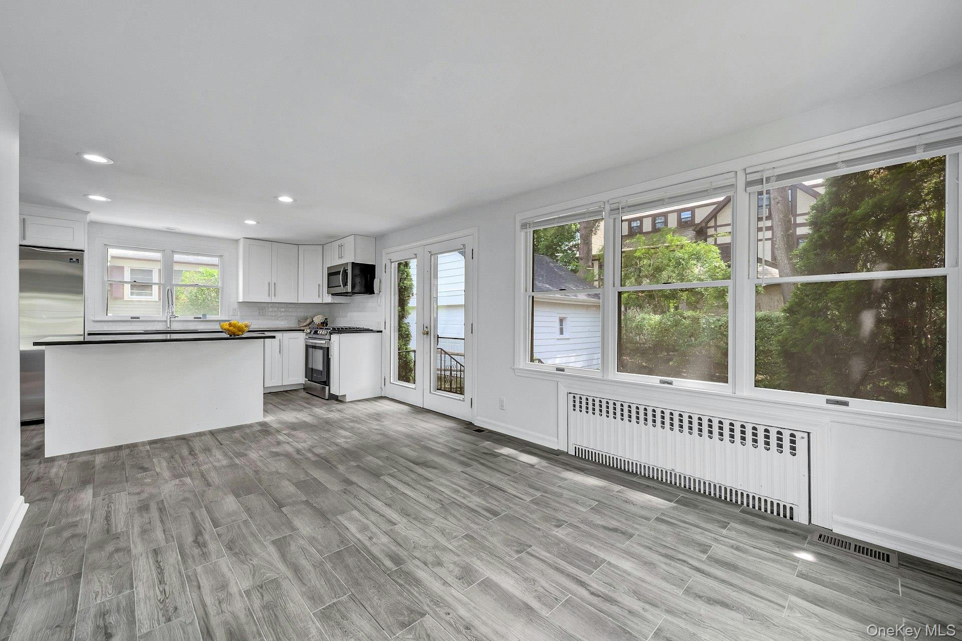 10 Carman Road Scarsdale, NY 10583 - Photo 13 of 32 Kitchen with center island and stainless appliances and doors to yard