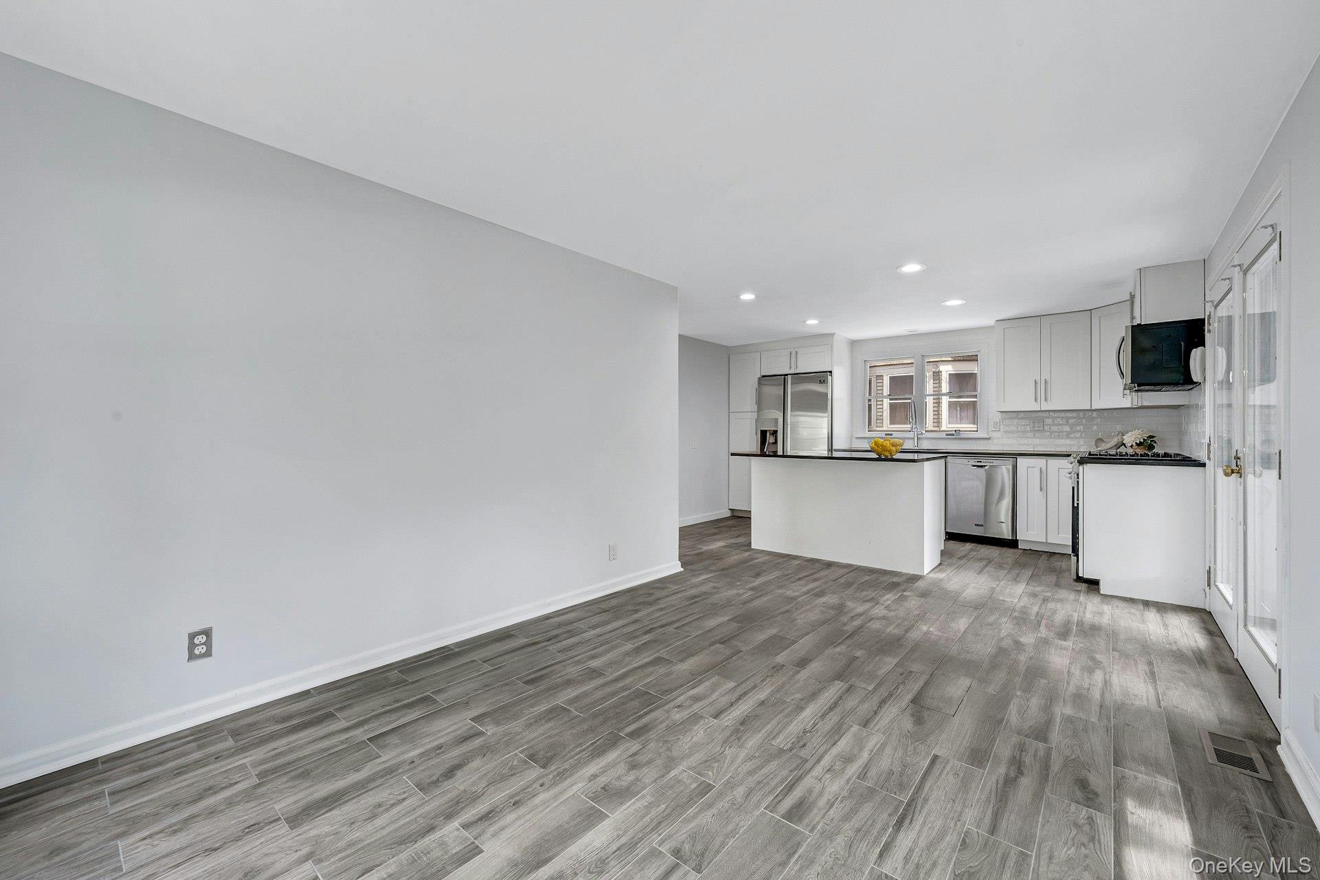 10 Carman Road Scarsdale, NY 10583 - Photo 14 of 32 Kitchen with center island and stainless appliances and doors to yard