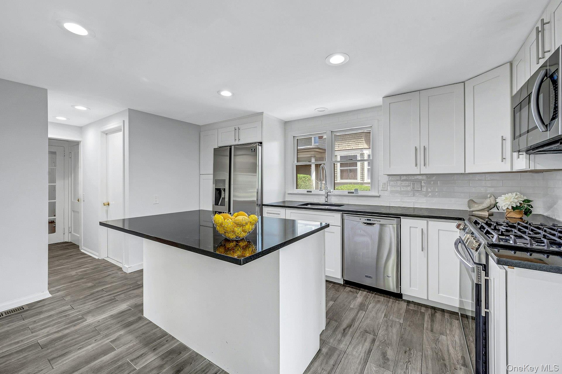 10 Carman Road Scarsdale, NY 10583 - Photo 8 of 32 Kitchen with center island and stainless appliances and doors to yard