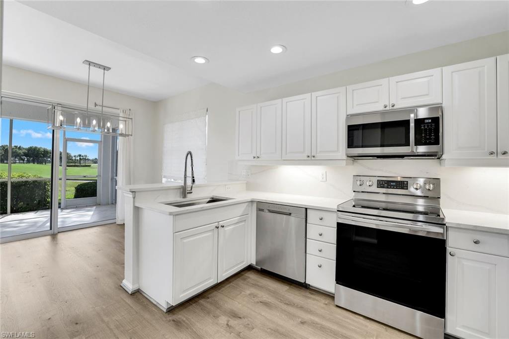 a kitchen with stainless steel appliances a stove sink and microwave