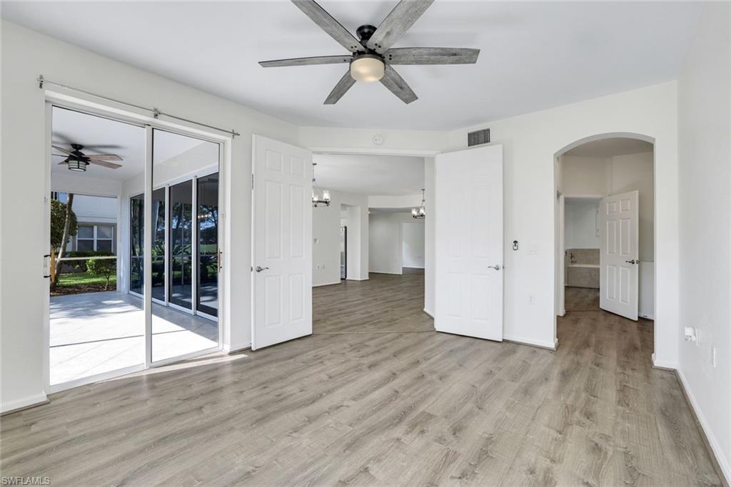 6875 Ascot Drive, Unit 6 Naples, FL 34113 - Photo 13 of 31 a view of a livingroom with wooden floor and a ceiling fan