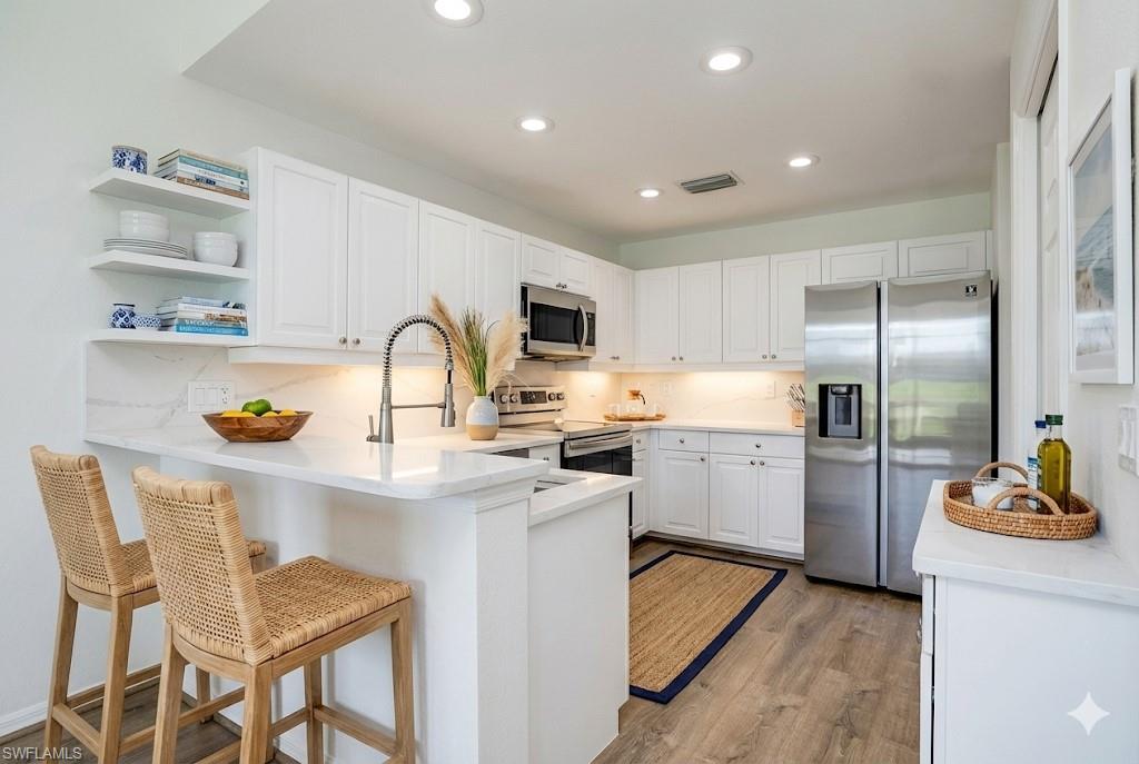 6875 Ascot Drive, Unit 6 Naples, FL 34113 - Photo 2 of 31 a kitchen with a refrigerator counter top space and cabinets