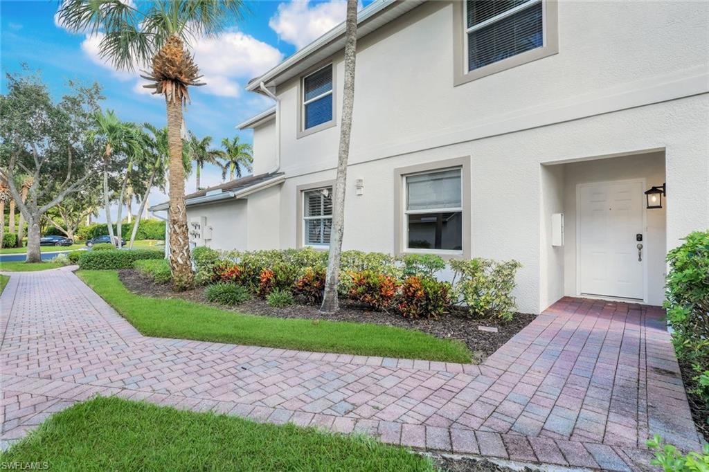6875 Ascot Drive, Unit 6 Naples, FL 34113 - Photo 24 of 31 a front view of a house with a yard and potted plants