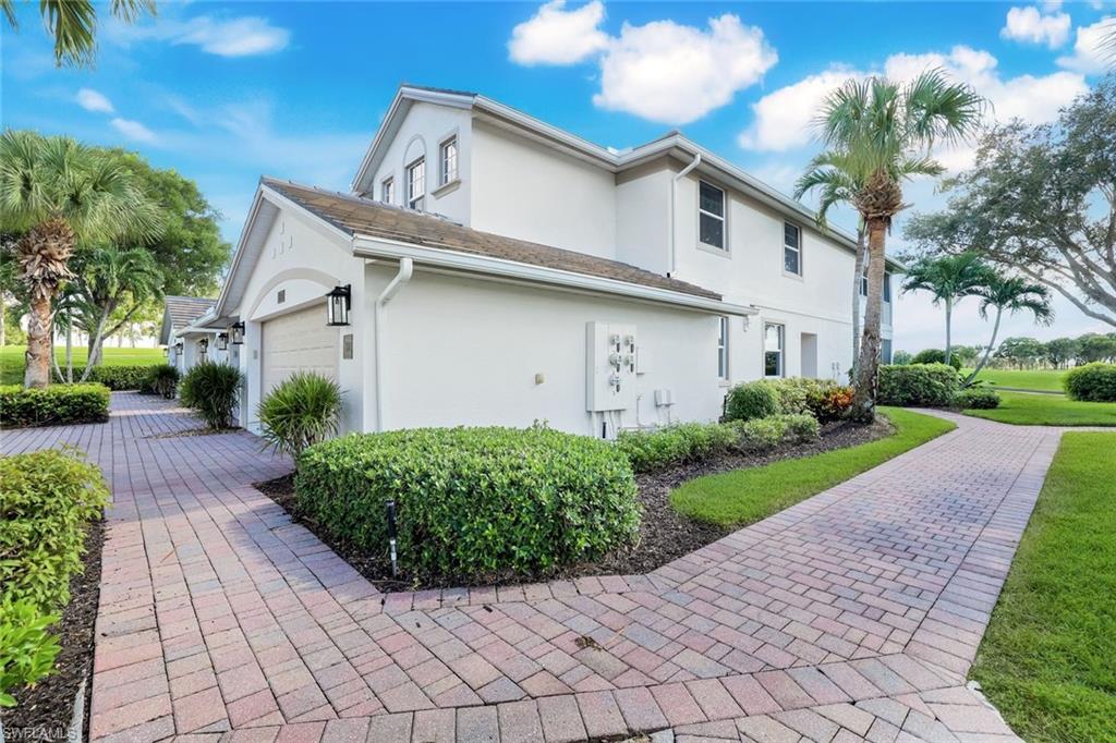 6875 Ascot Drive, Unit 6 Naples, FL 34113 - Photo 25 of 31 a view of a white house with a large trees plants and large tree