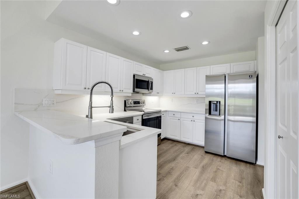 6875 Ascot Drive, Unit 6 Naples, FL 34113 - Photo 3 of 31 a kitchen with a refrigerator sink and white cabinets
