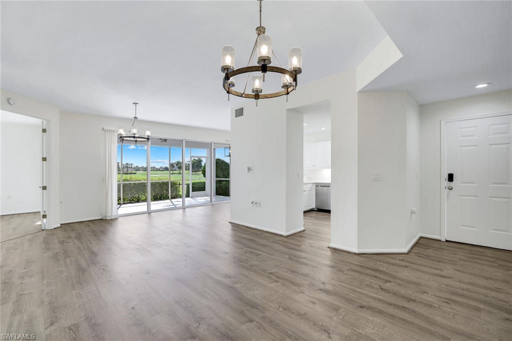 6875 Ascot Drive, Unit 6 Naples, FL 34113 - Photo 8 of 31 a view of an empty room with a window and wooden floor