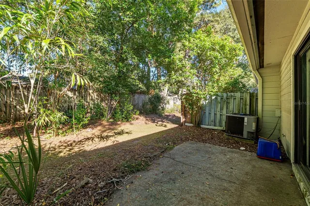 a view of a yard with plants and wooden fence