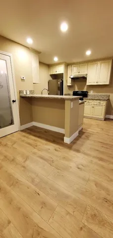 a view of a kitchen with stainless steel appliances kitchen island granite countertop a stove and a sink