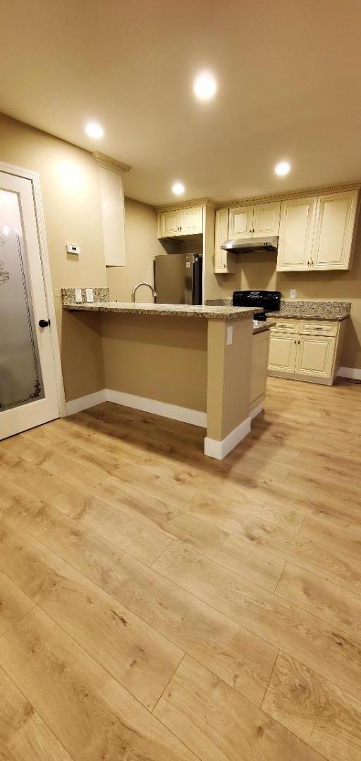 a view of a kitchen with stainless steel appliances kitchen island granite countertop a stove and a sink