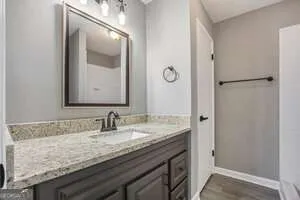a bathroom with a granite countertop sink and a mirror