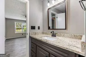 a bathroom with a granite countertop sink and a mirror