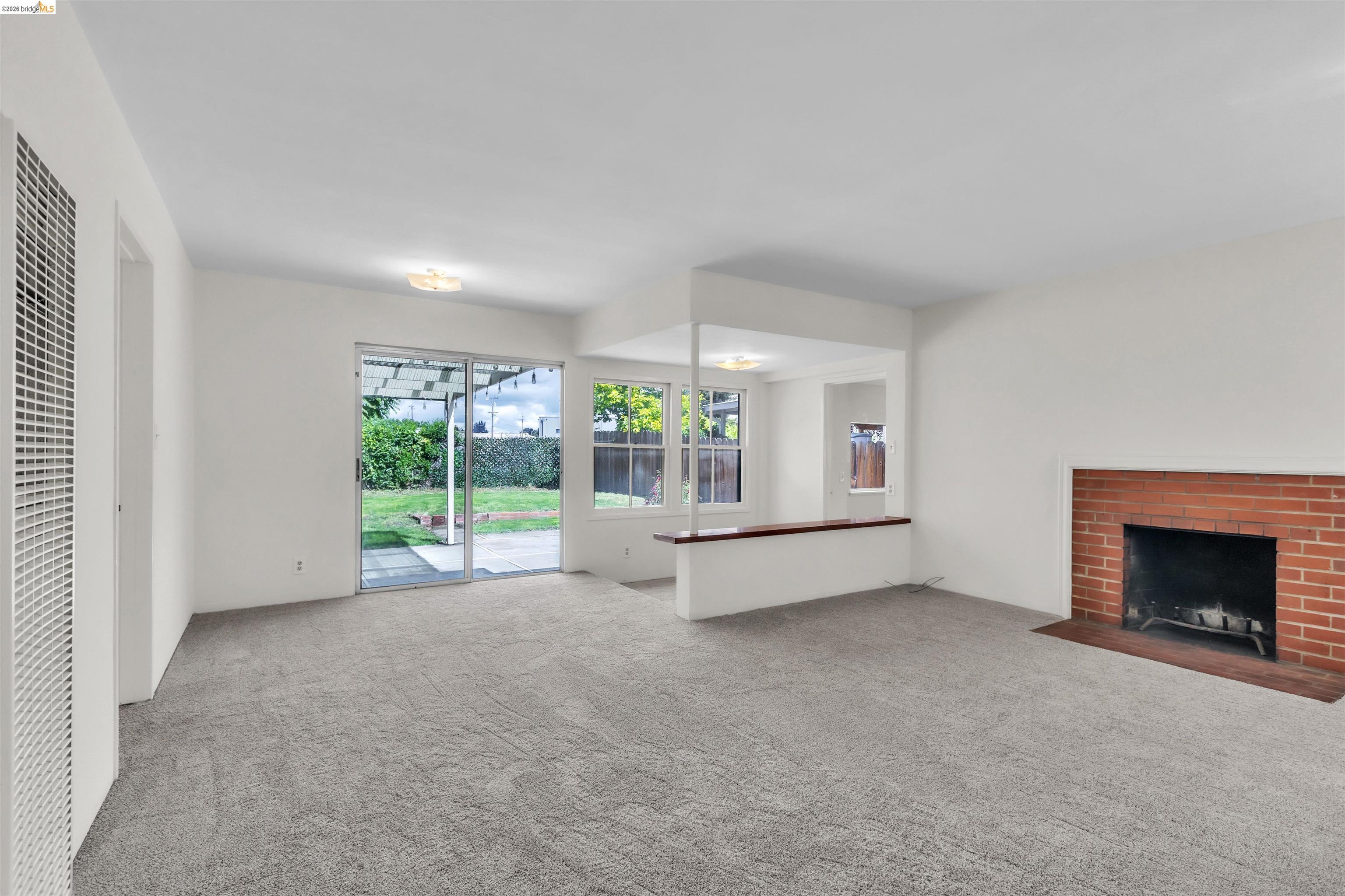 621 Paseo Del Rio San Lorenzo, CA 94580 - Photo 3 of 24 Spacious interior room featuring light gray carpeting, a brick fireplace, and white walls