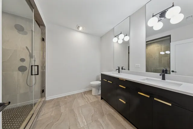 a spacious bathroom with a double vanity sink mirror and shower