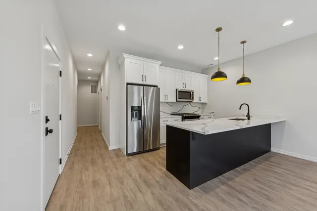 a kitchen with stainless steel appliances granite countertop a refrigerator and a sink