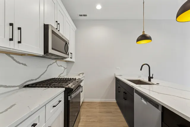 a kitchen with a sink a stove and a microwave