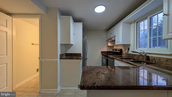 a kitchen with a refrigerator and a stove top oven