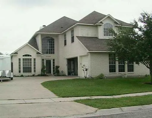 a front view of a house with a yard and trees