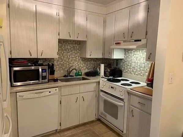 a kitchen with cabinets stainless steel appliances and sink