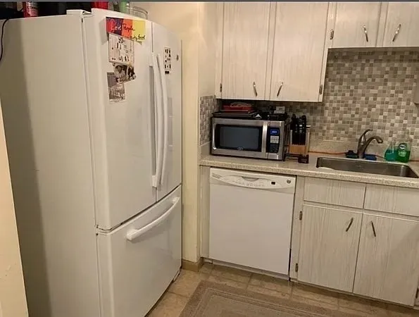 a kitchen with stainless steel appliances a refrigerator sink and cabinets