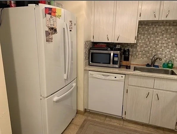 10 Scottfield Road, Unit 14 Boston, MA 02134 - Photo 4 of 7 a kitchen with stainless steel appliances a refrigerator sink and cabinets