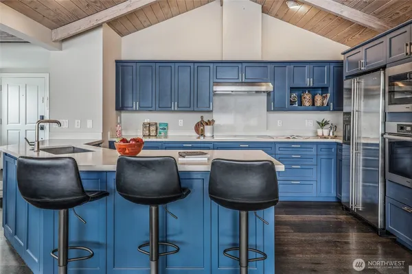 a kitchen with stainless steel appliances a table chairs and a refrigerator