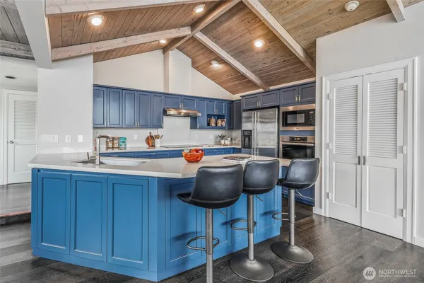 a kitchen with stainless steel appliances a table chairs and a refrigerator