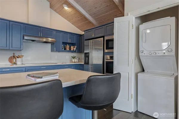 a kitchen with stainless steel appliances granite countertop a table chairs refrigerator and sink