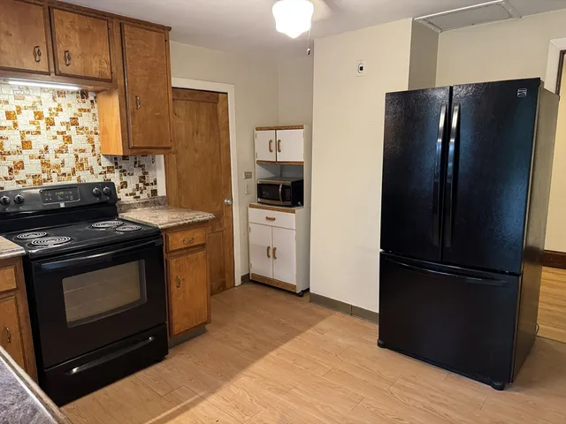 a kitchen with stainless steel appliances granite countertop a refrigerator stove and microwave