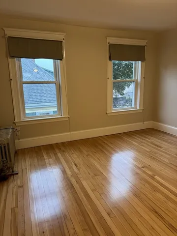 an empty room with wooden floor and a window