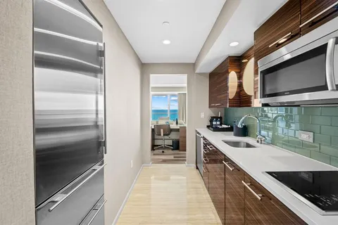 a kitchen with kitchen island granite countertop a sink stainless steel appliances and cabinets