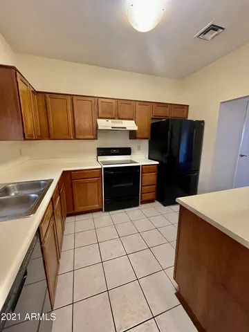 a kitchen with stainless steel appliances a stove a sink and a refrigerator