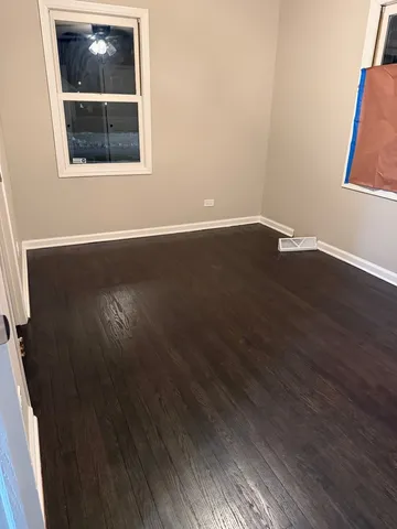 a view of a small space with wooden floor and a window